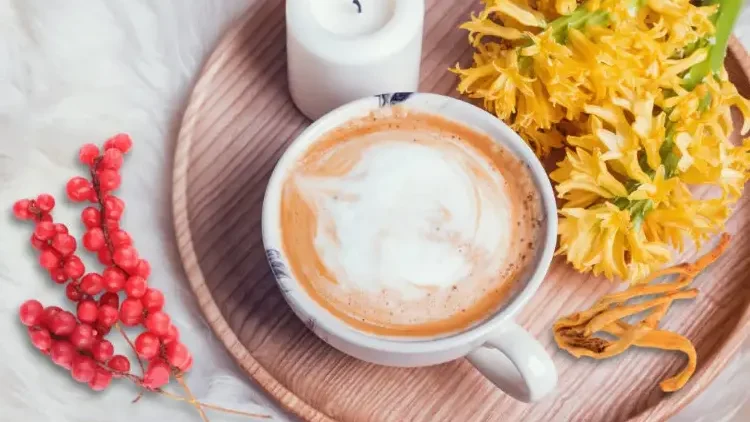A wooden tray with a candle, berries, and a cup of Cordyceps coffee