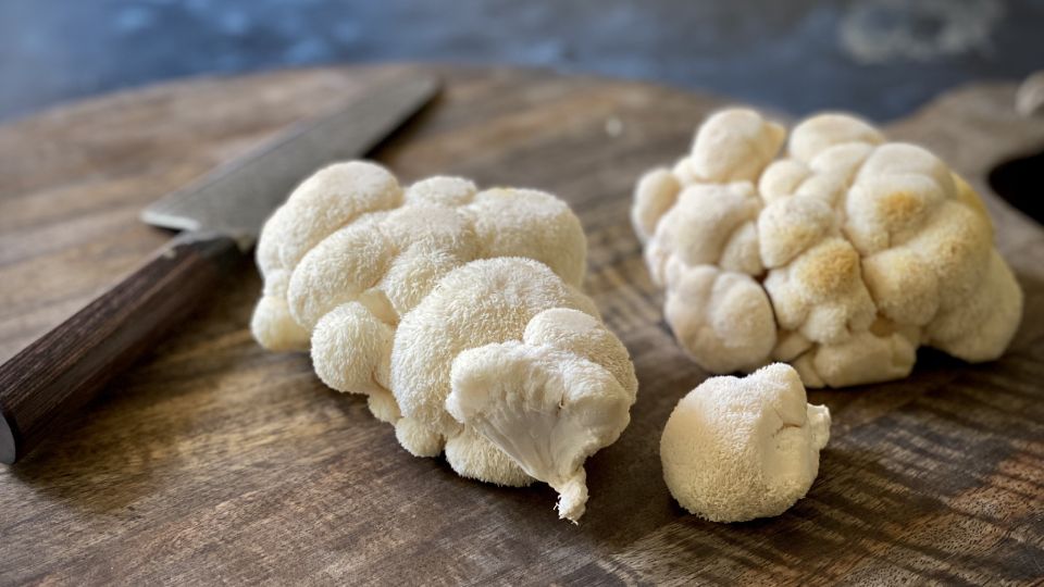 Lion's mane mushrooms on chopping board with a knife